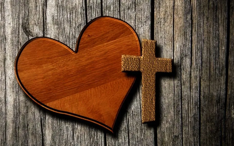 Wooden heart beside a small cross, a symbol of God's love shown through Jesus Christ