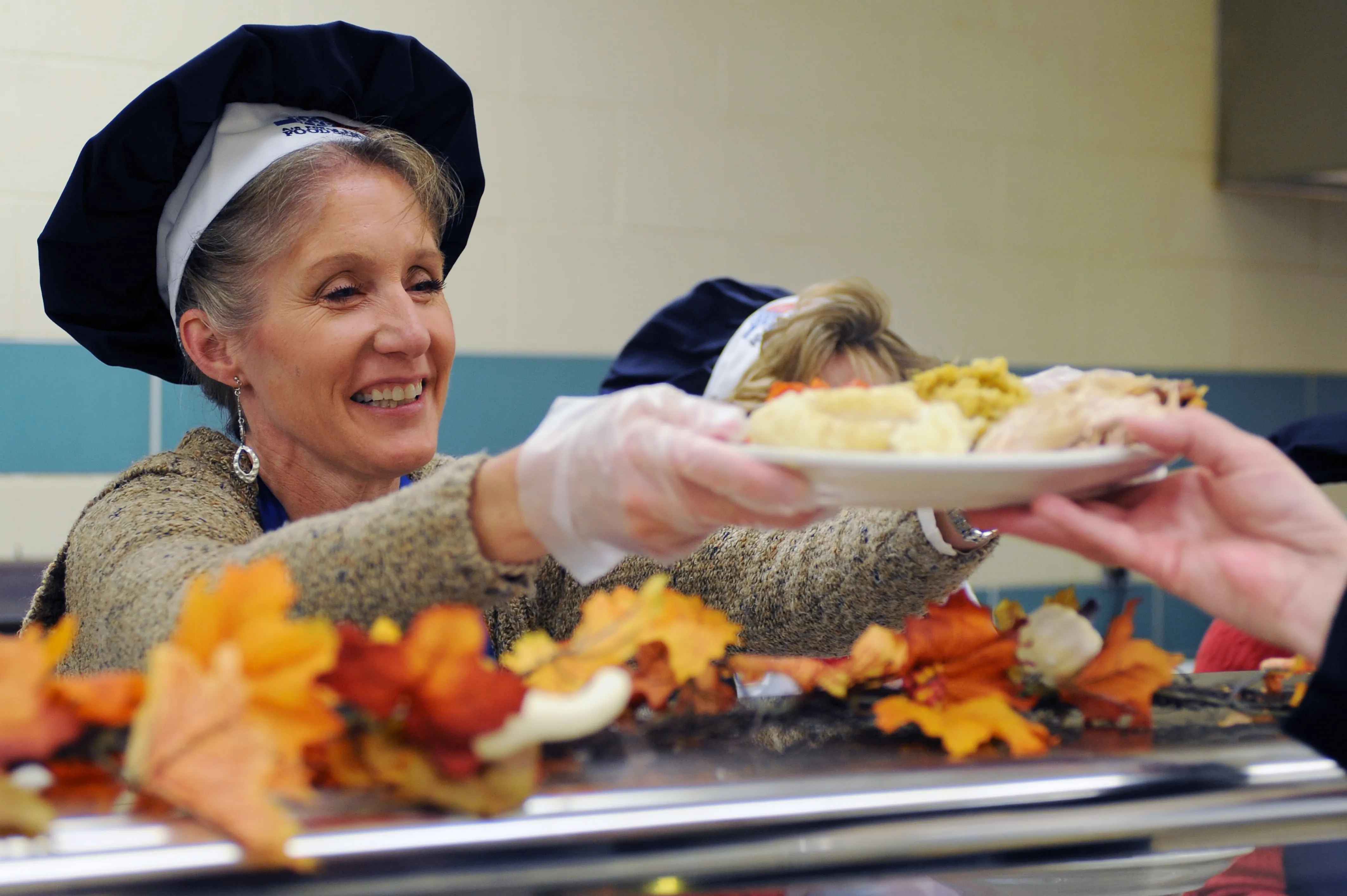 Smiling volunteer serving a plate of food, illustrating Christian service and true worship