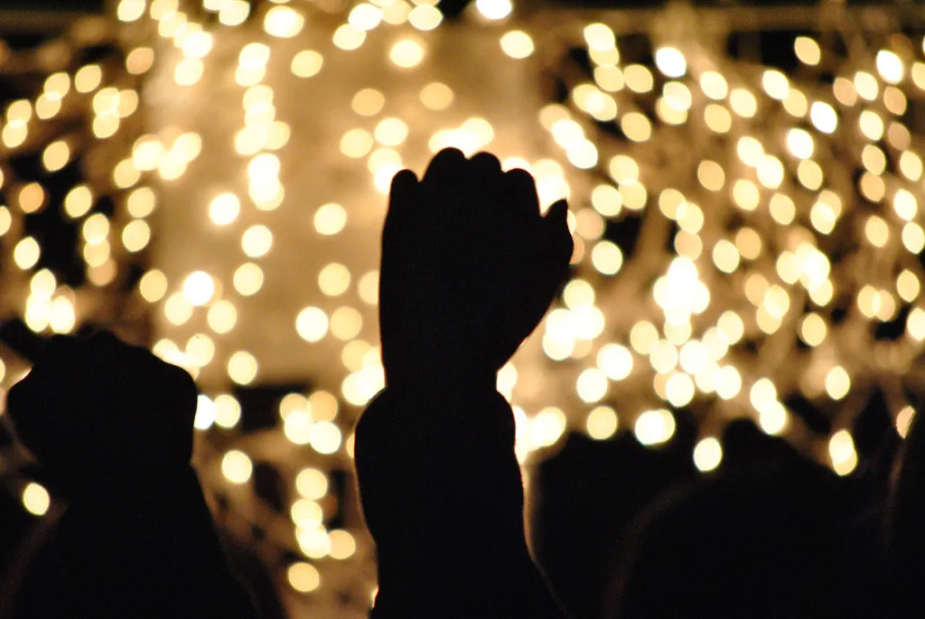 Hand raised in worship against glowing lights, for a study of spiritual gifts