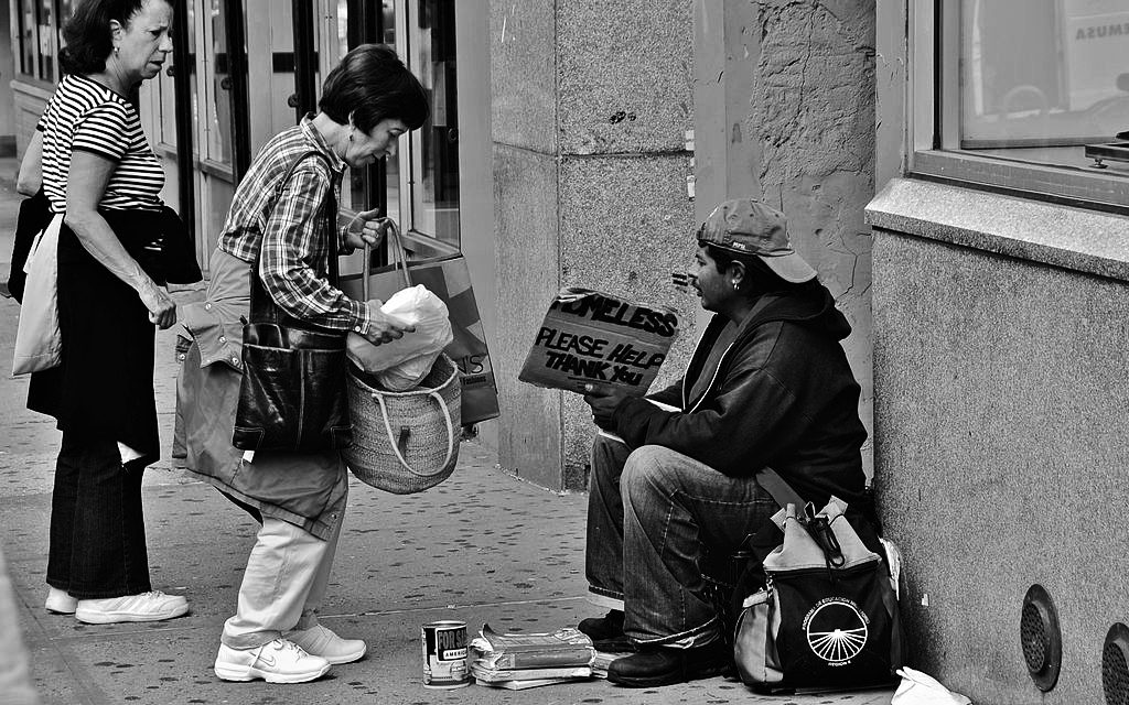A Good Samaritan Feeding or Giving Money To A Homeless Man